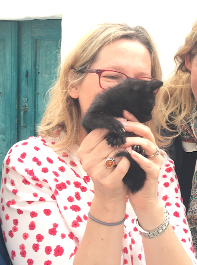 A mother holding a black kitten